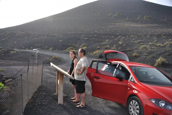 Touristenpärchen am Volcán Teneguía auf La Palma. Generell lässt sich die Insel am besten mit dem Mietwagen erkunden (ab 104€/1 Woche).