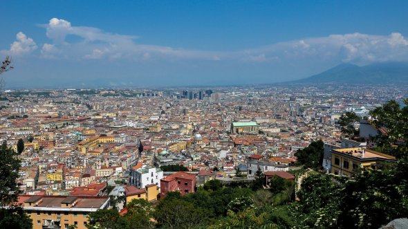 Blick auf die italienische Großstadt Neapel mit dem Vesuv am rechten Bildrand. Hier gibt es die beste Pizza Italiens.