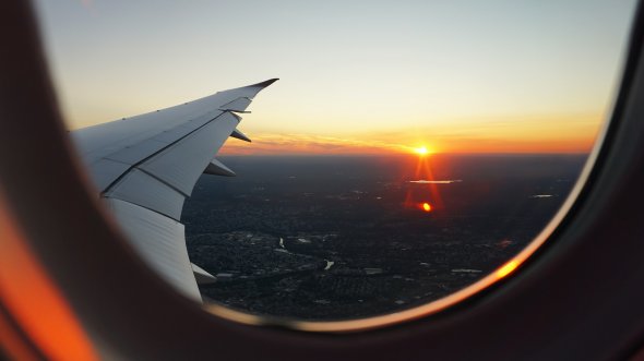 Flugzeugfensteransicht des Himmels während der goldenen Stunde